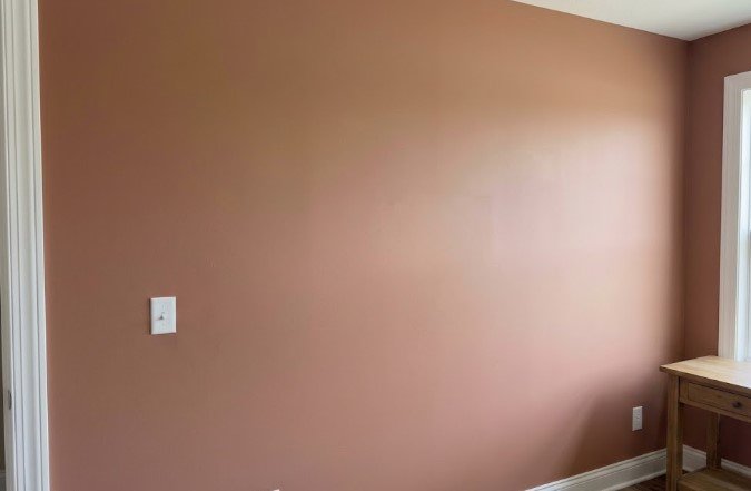 The same wall painted a warm terracotta color, smooth with no patches showing